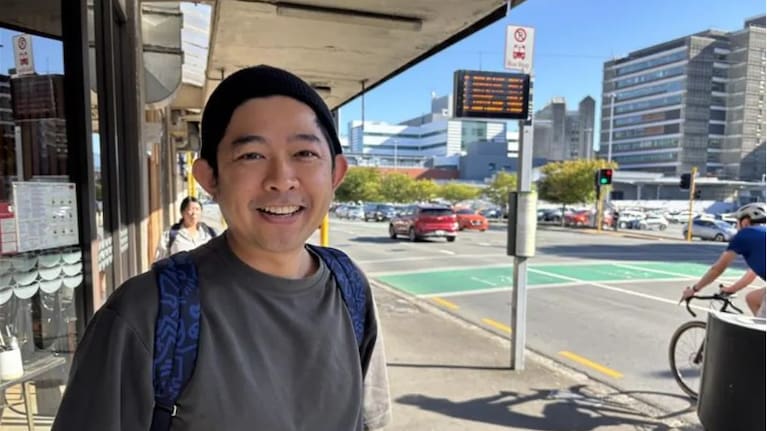 John Ng waits for his bus in Wellington. 