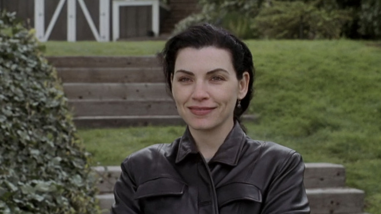 Julianna Margulies' Carol Hathaway is seen in closeup standing on a grassy bank in ER