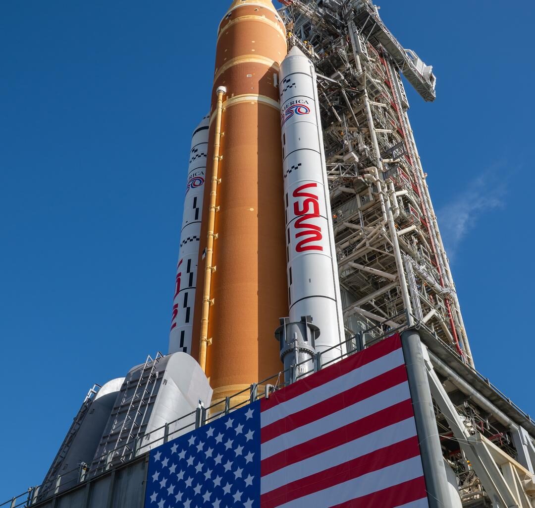 This image shows NASA’s SLS (Space Launch System) and Orion spacecraft rolling out of the Vehicle Assembly Building at NASA’s Kennedy Space Center in Florida