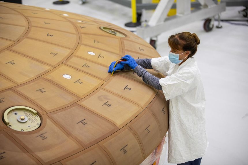 Darlene Beville of contractor ASRC Federal inspects the Artemis II heat shield in July 2020. The heat shield protects the Orion capsule and astronauts during reentry through Earth’s atmosphere.