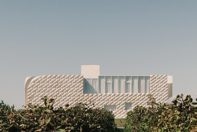 arches and voids carve winery’s monolithic white facade in georgia