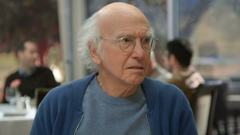 Larry David as himself scowling at dinner in Curb Your Enthusiasm