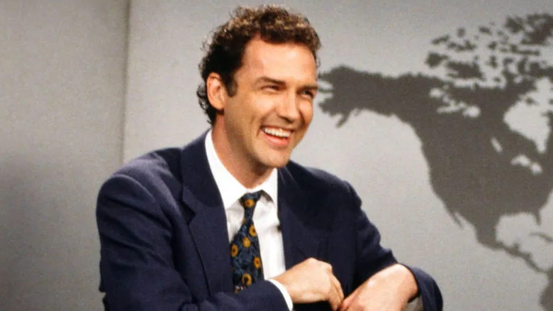 Norm Macdonald laughing while hosting Weekend Update on SNL