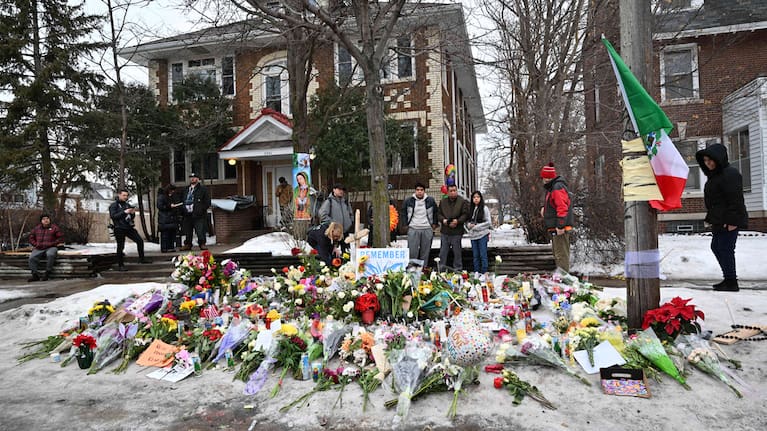 People gather around a makeshift memorial honouring Renee Good who was fatally shot by a federal law enforcement agent near the site of the shooting in Minneapolis.