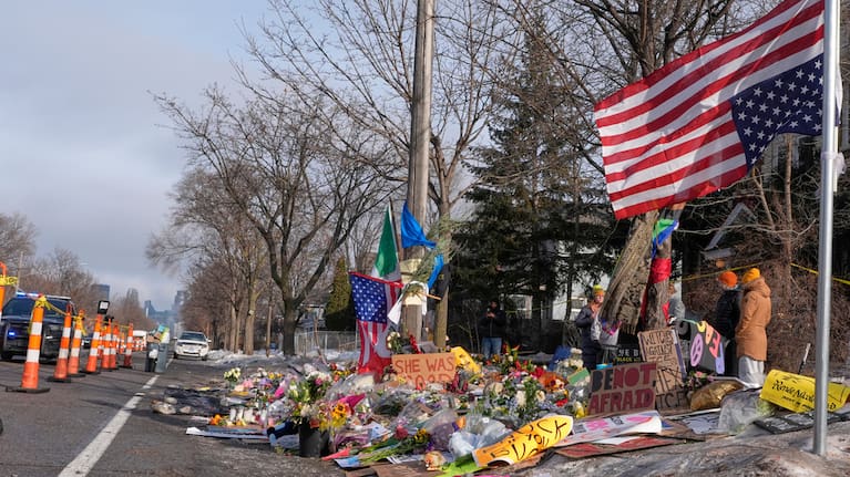 People stand near a memorial at the site where Renee Good was fatally shot by an ICE agent.