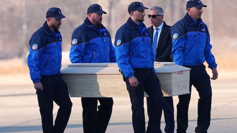 Police officers carry a coffin with the body of one of six Italians at the Military Airport in Sion, Swiss Alps.