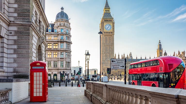 Red telephone box and double-decker bus on Parliament square and Big Ben tower, London
