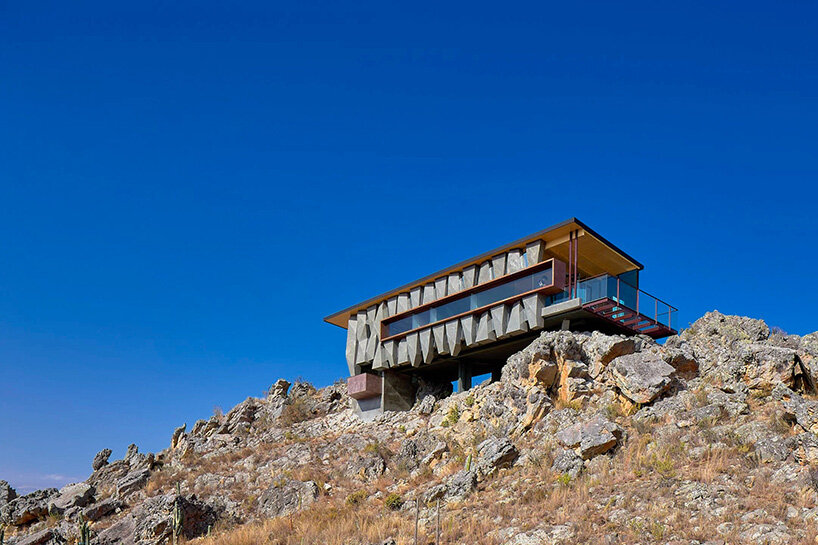 reflective glass surfaces mirror the rocky terrain across andean cabin by rtresarquitectos