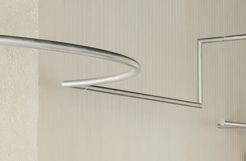 continuous steel rail traces shanghai showroom’s sculptural interior, like a freehand drawing