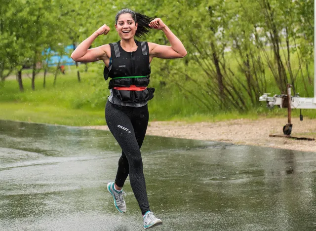Buffalo, Minnesota, USA - May 20, 2017 Murph Challenge 2017, Happy athletic girl coming back from 1 mile run and flexing her biceps