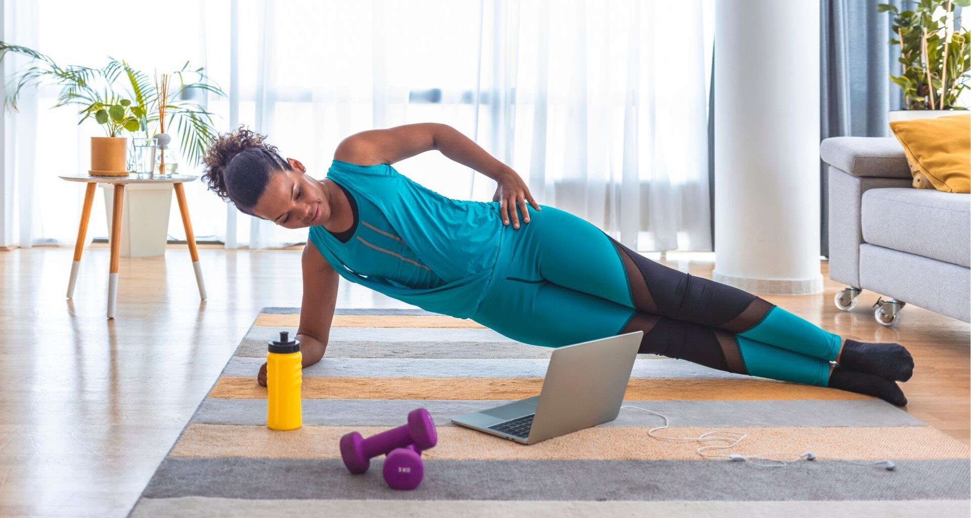 woman in side plank on a yoga mat at home