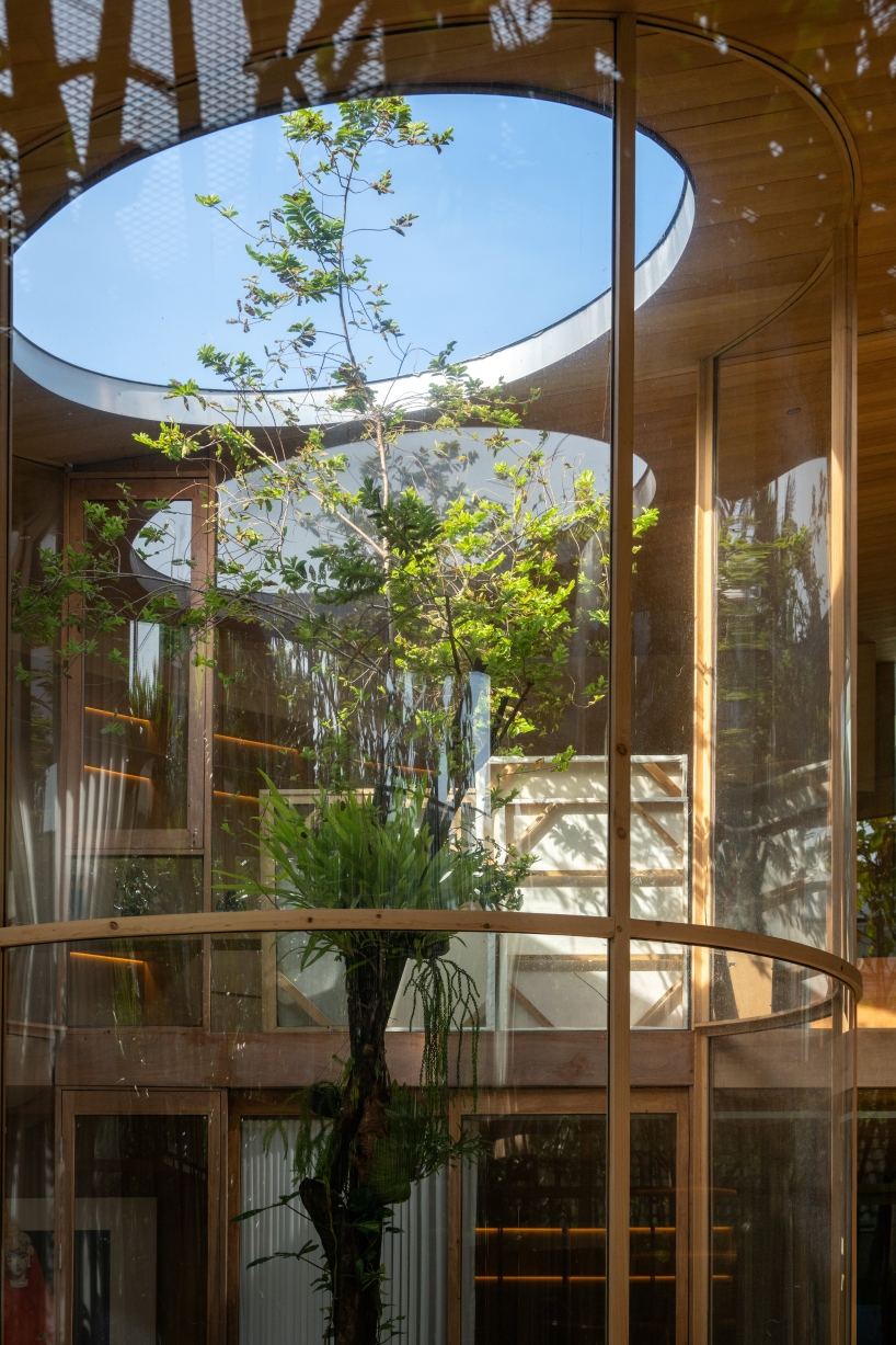 curved glass atriums penetrate residence’s aluminum roof in bangkok