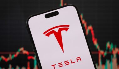 In this photo illustration, the Tesla logo is displayed on a smartphone screen