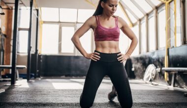 Woman kneeling with hands on hips at the gym studio in activewear