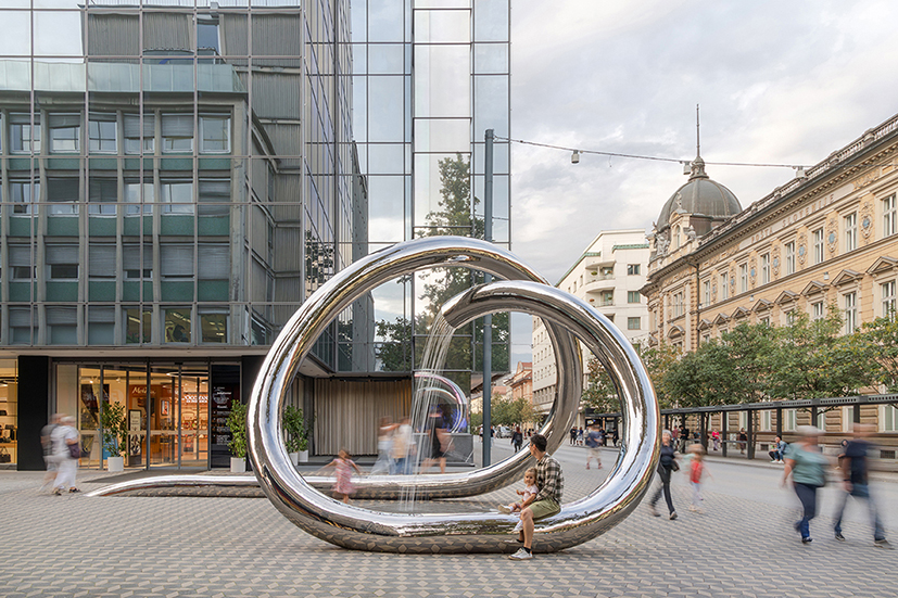 continuous steel loop forms water sculpture reflecting ljubljana’s urban fabric
