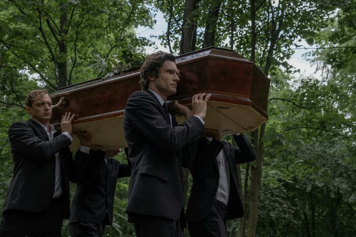 Men in suits carrying a coffin through a forest, illustrating dramatic patient stories of leaving the hospital against medical advice.