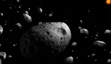 An illustration of a large round asteroid covered in craters surrounded by smaller asteroids with a orange glowing sun in the top left of the image.