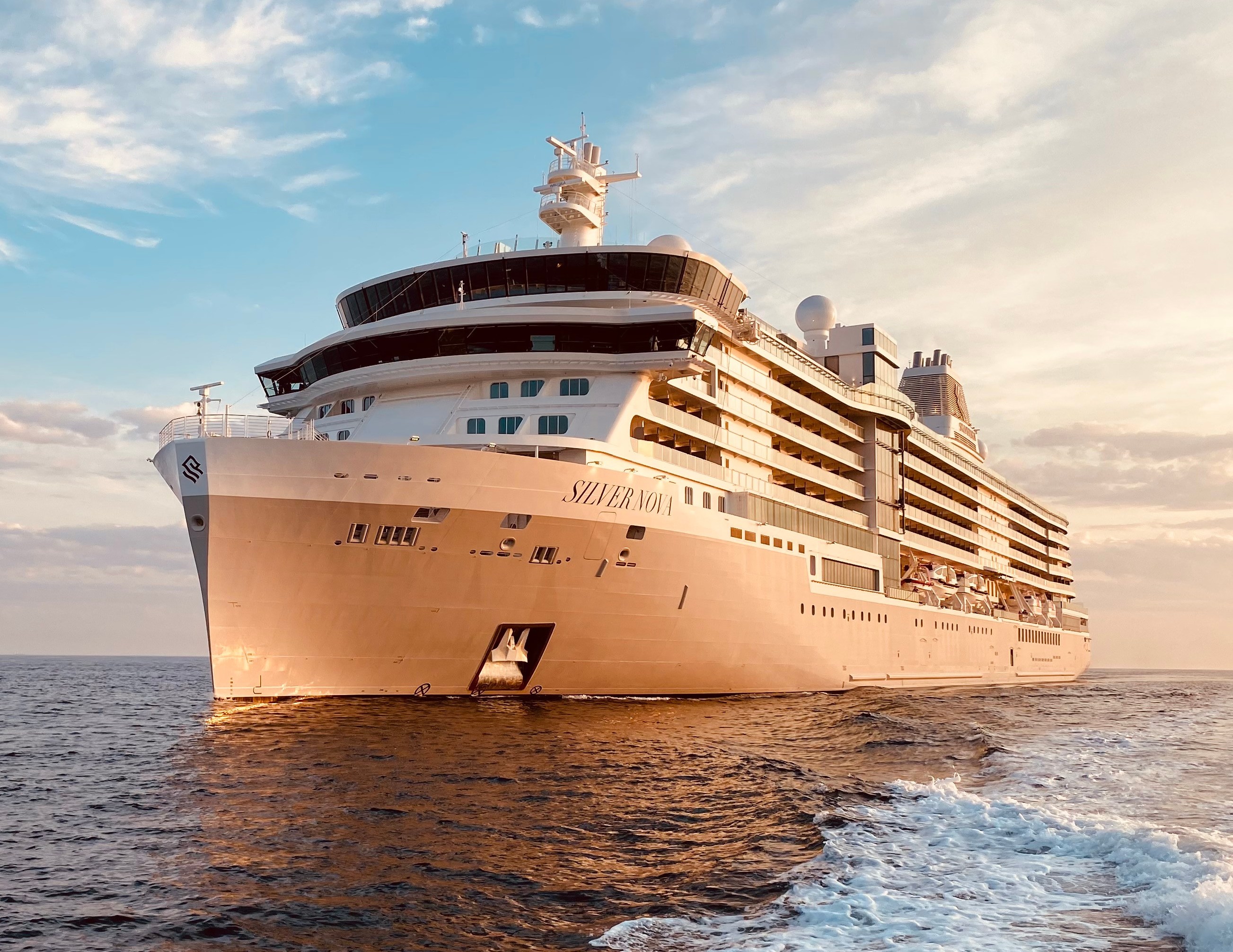 The cruise ship Silver Nova on the ocean with a partly cloudy sky.
