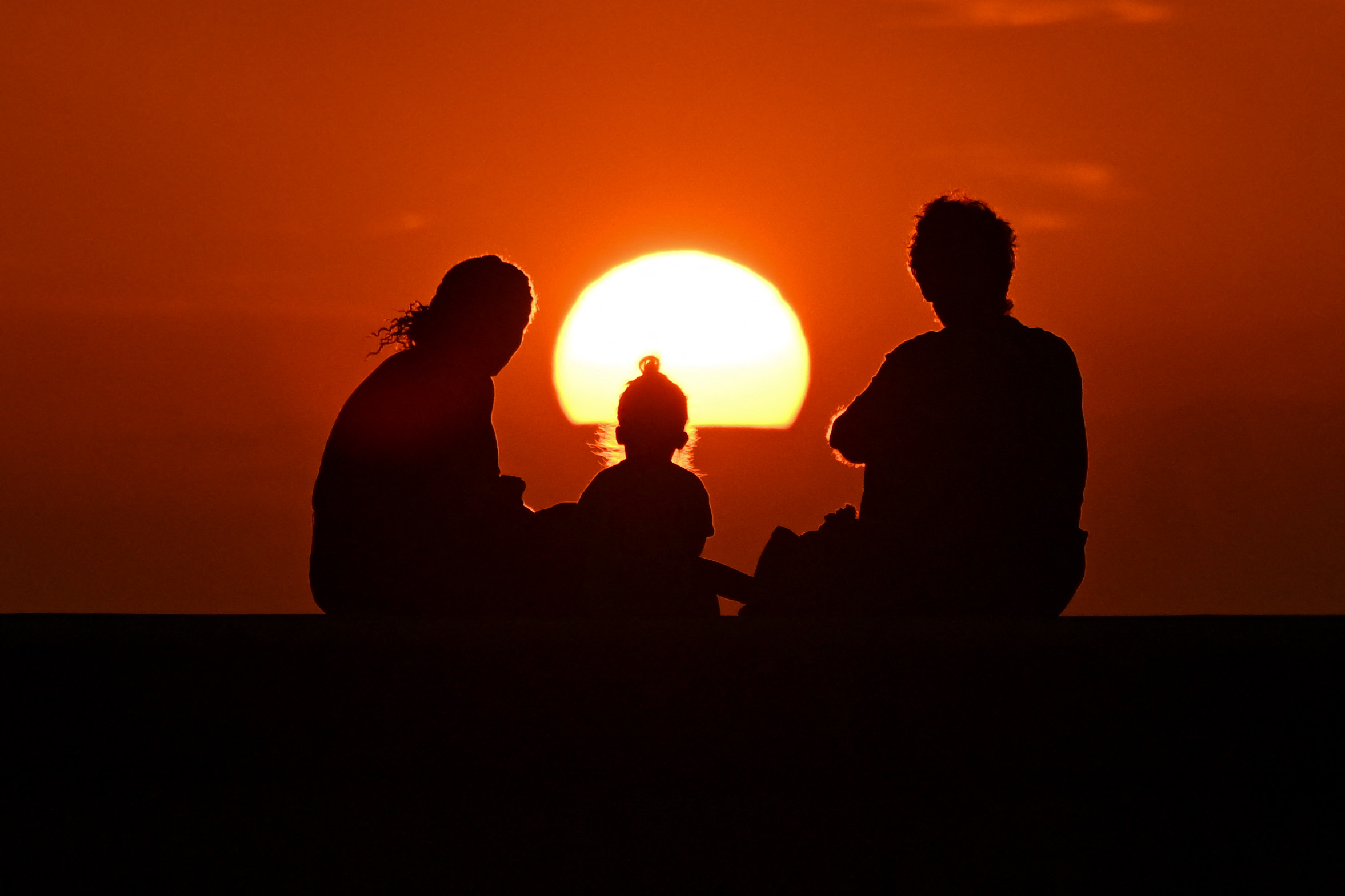 Silhouette of a family watching the sunset in Havana.