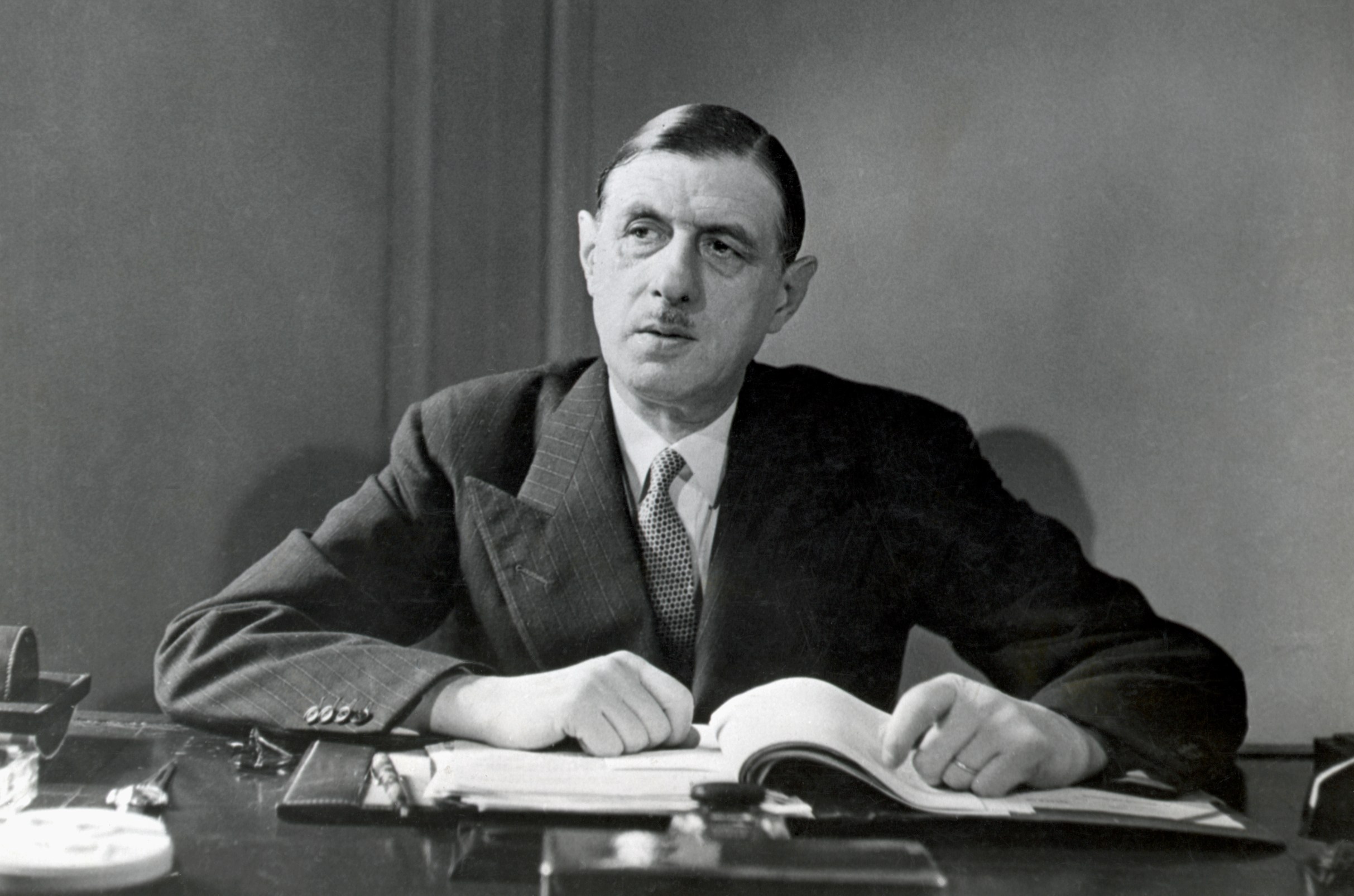 Portrait of Charles de Gaulle, a French soldier and statesman, seated at a desk.