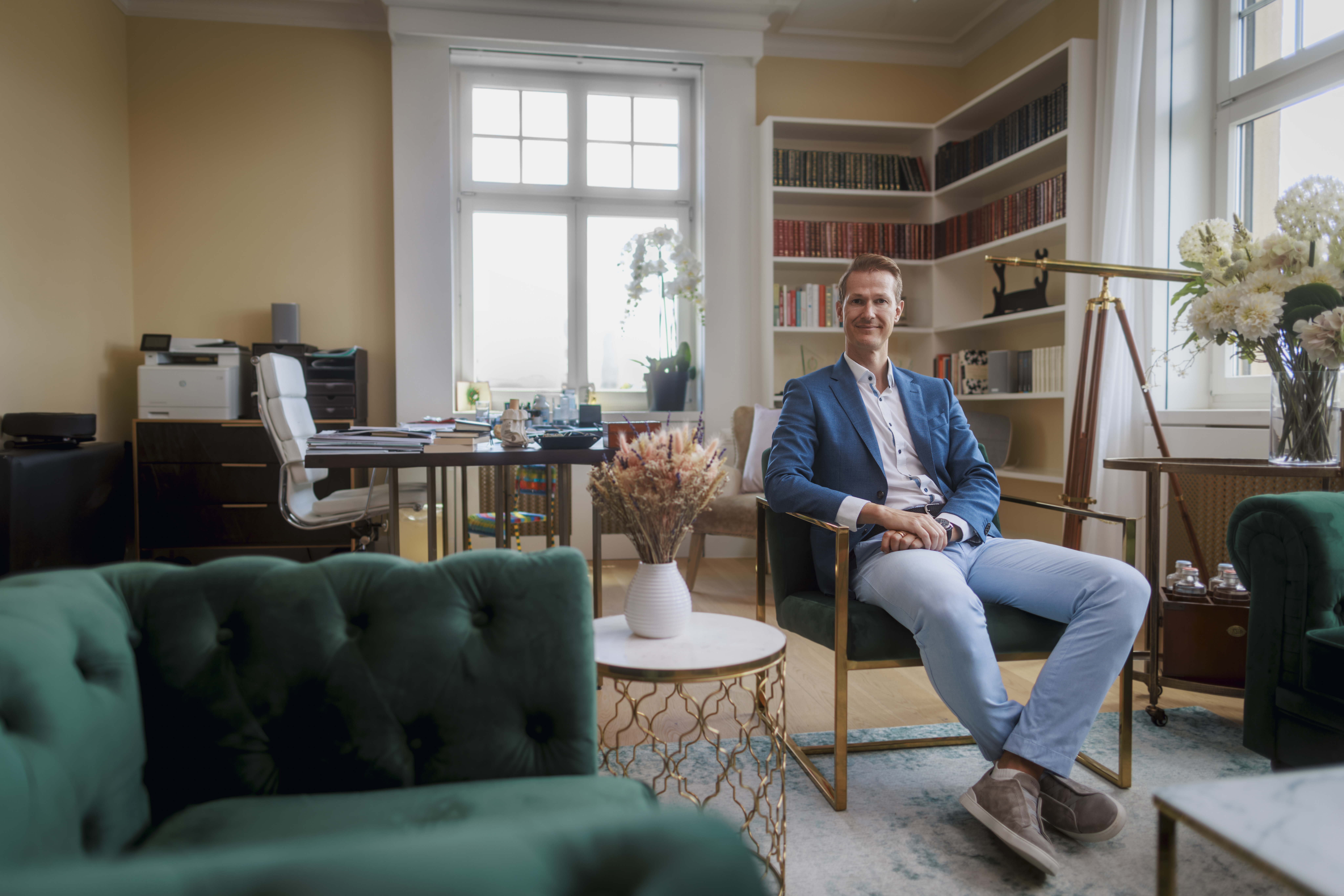 Jan Gerber, 42, founder and CEO of Paracelsus Recovery, sitting in a teal armchair in an office.