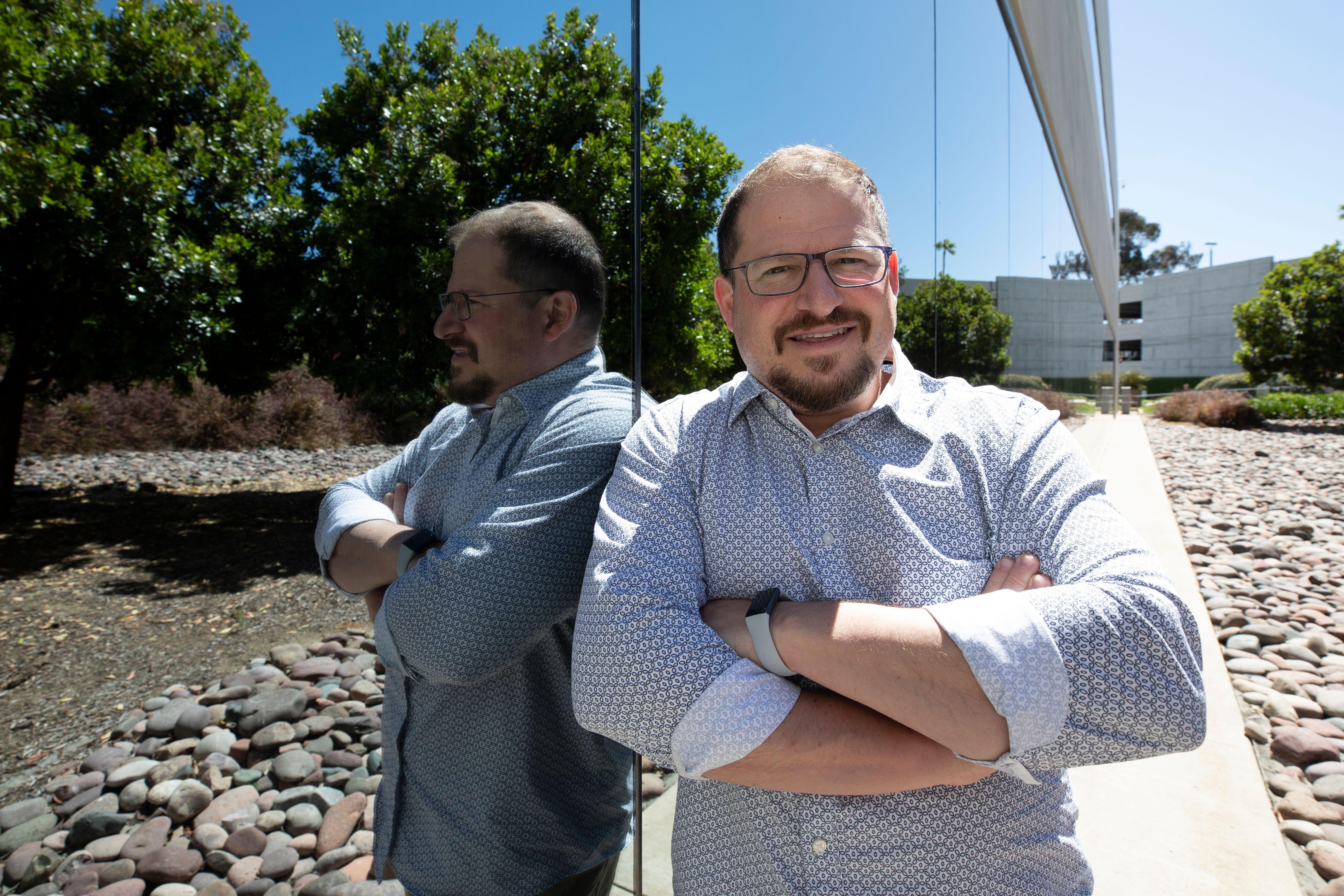 Cristiano Amon, CEO of Qualcomm, standing outdoors with arms crossed.