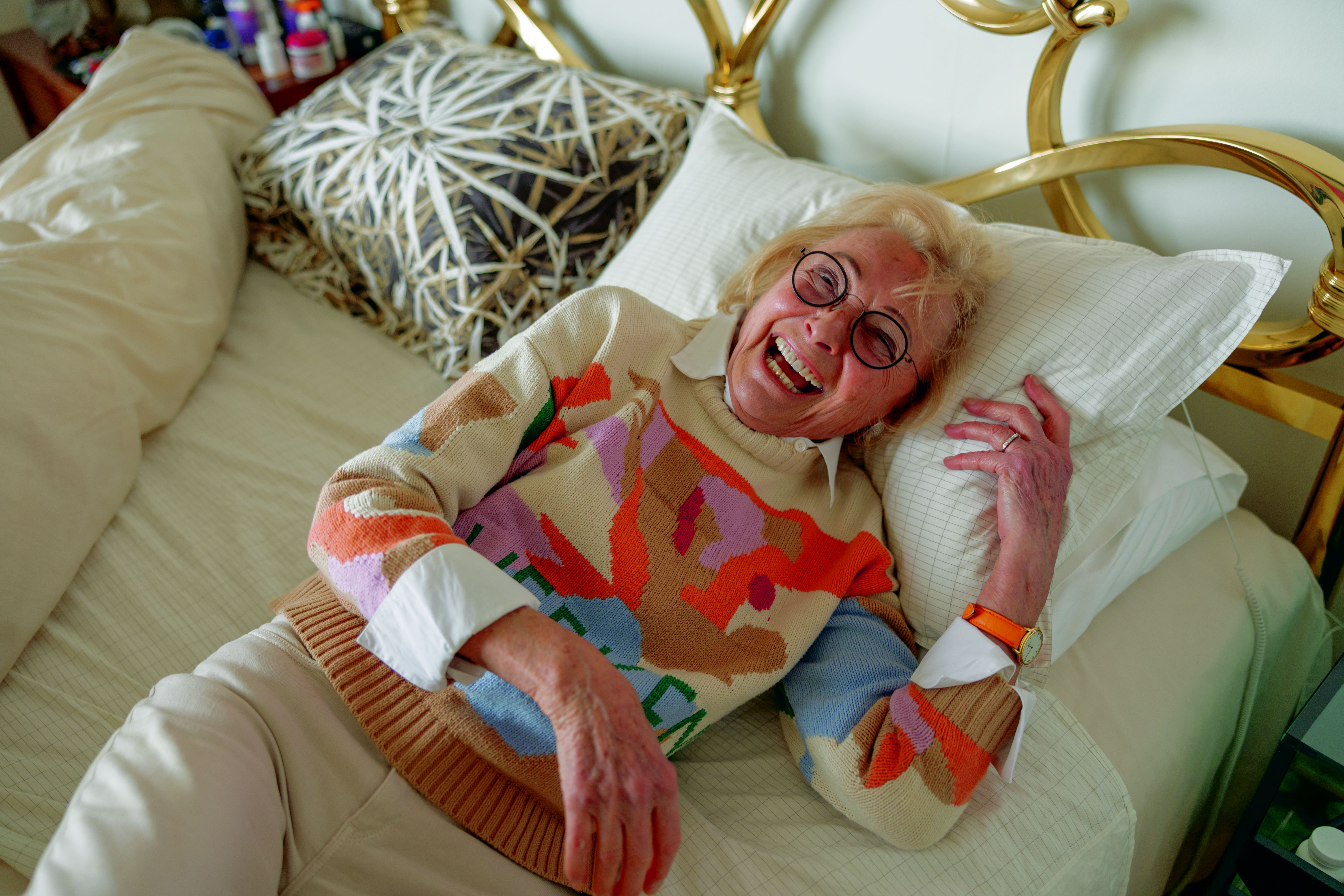 Helga Sands, a biohacker and longevity fanatic, lying in her bed with grounding sheets and a big smile.