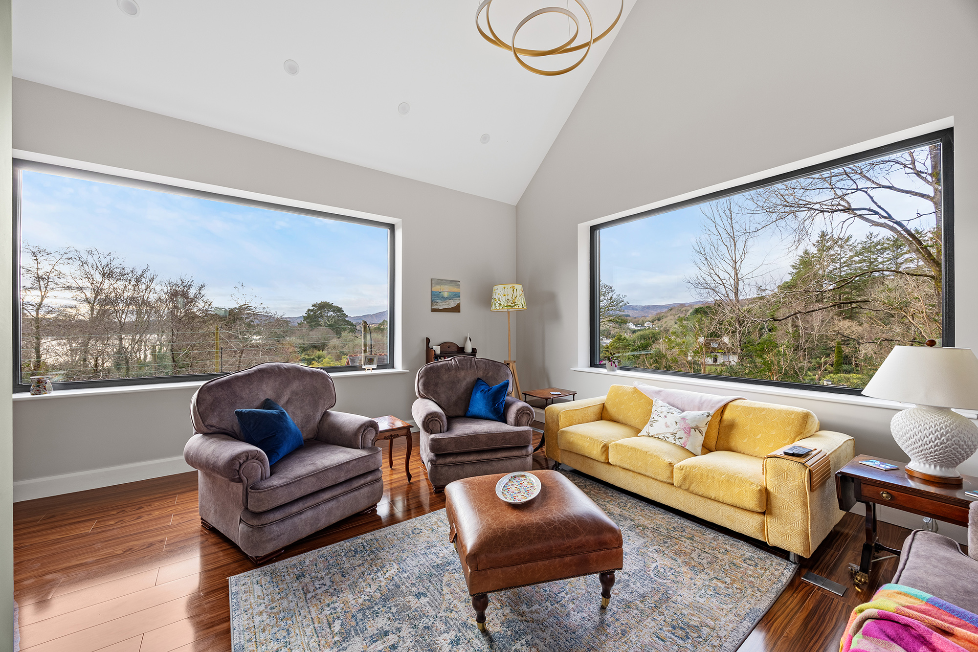 Living room with large windows overlooking a scenic landscape.