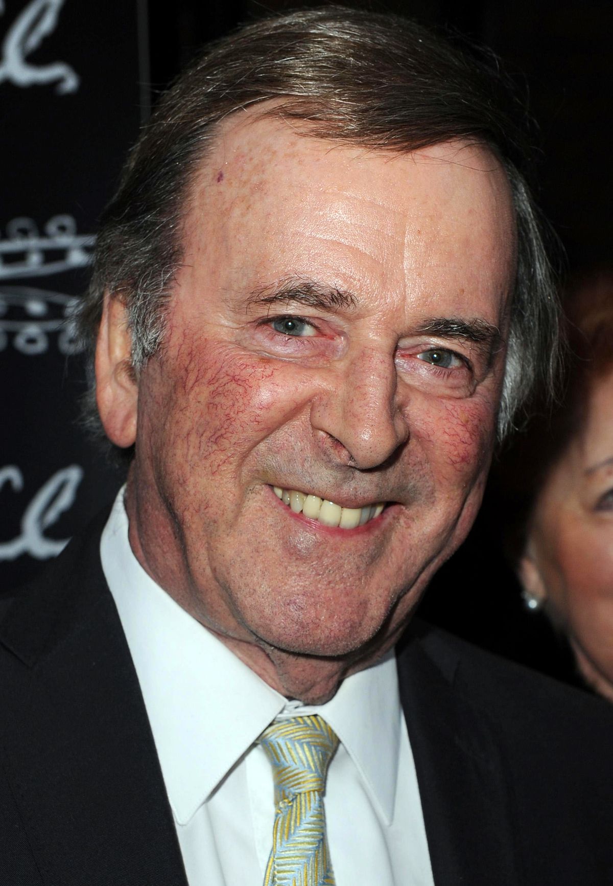 Sir Terry Wogan, smiling and wearing a suit and tie