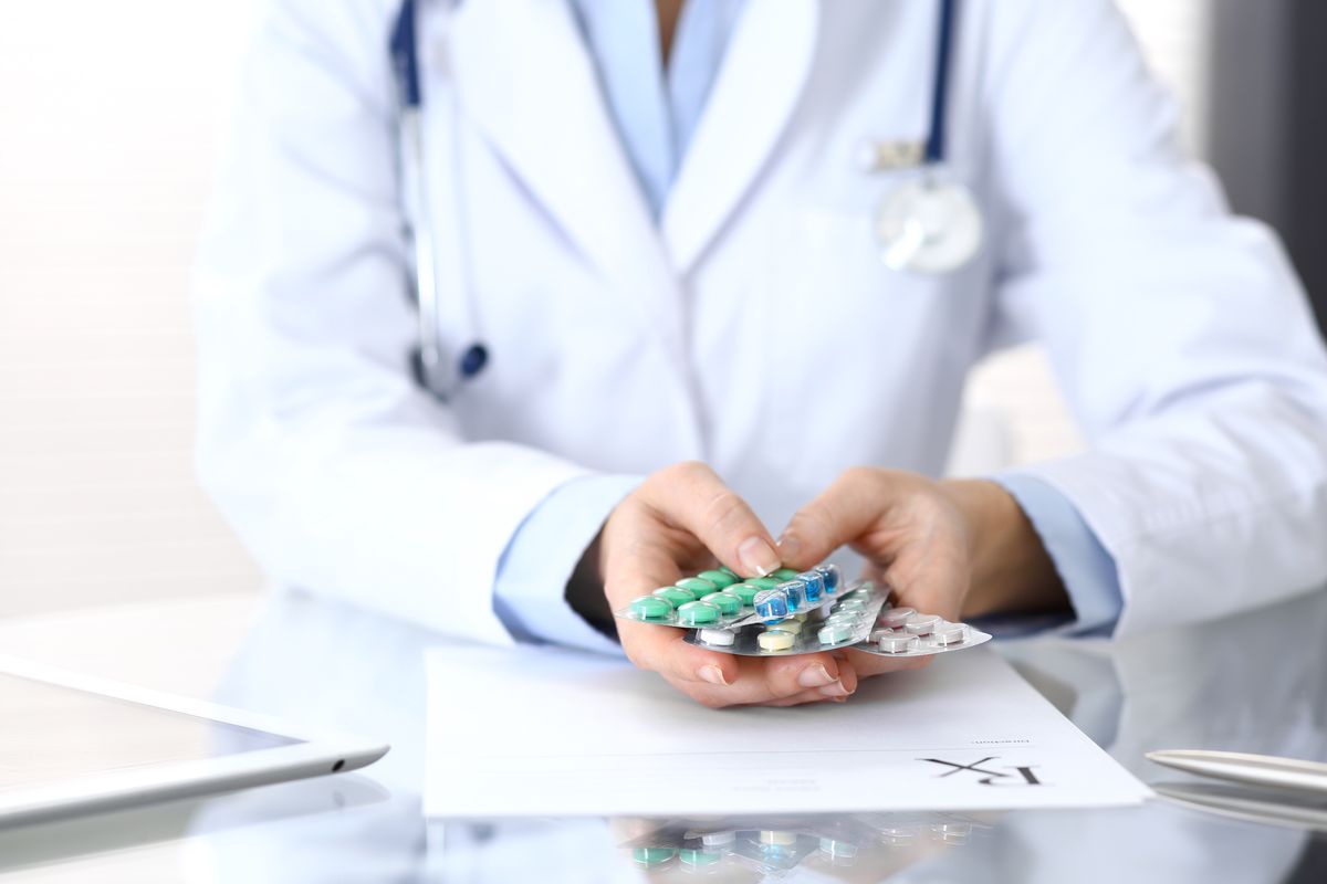 Doctor holding pack of different tablet blisters closeup