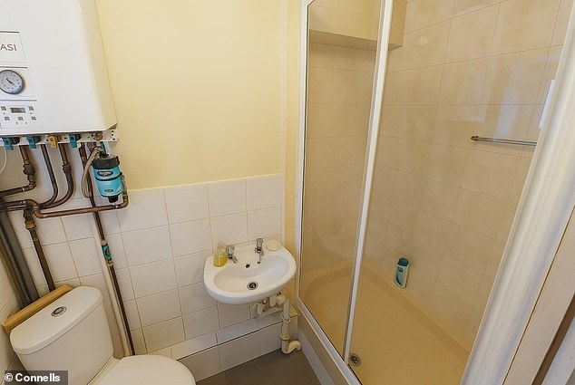 A photo of one of two shower rooms features details such as an unreadable shampoo bottle
