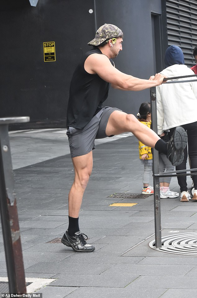 Luke, meanwhile, was photographed elsewhere, upbeat and smiling, dressed in gym gear with a flower tucked behind his ear as he stretched before heading out for a jog