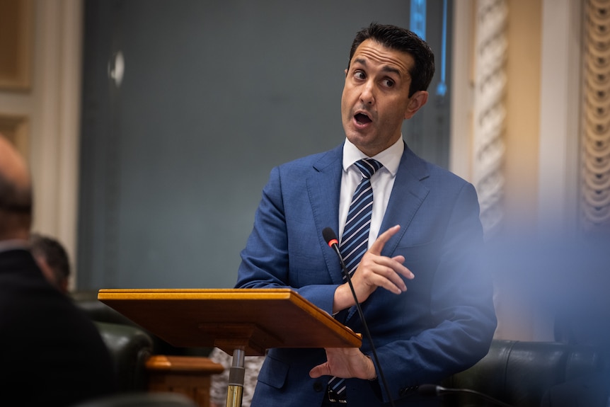 A man in a blue suit speaking in Queensland's state parliament.