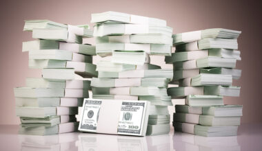 Pile of money stacked on reflective surface.