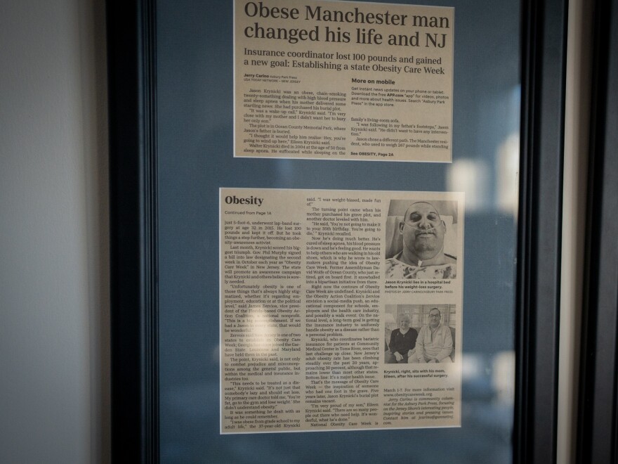 A framed article in the Asbury Park Press from 2020 describes Jason Krynicki's efforts to get New Jersey to recognize Obesity Care Week.