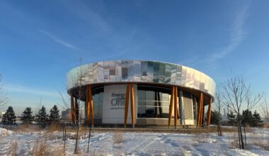 A building with a reflective roof in a snowy field.