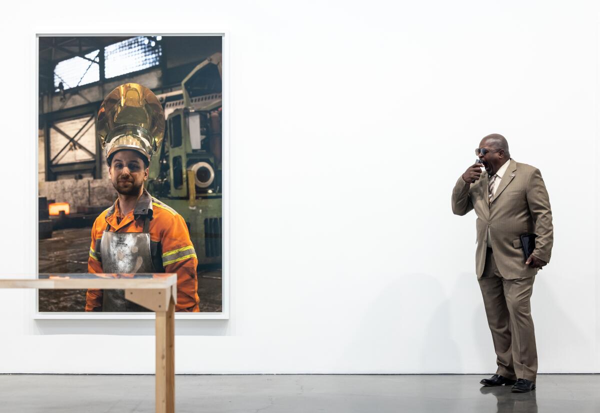 A man stands by a large photo.