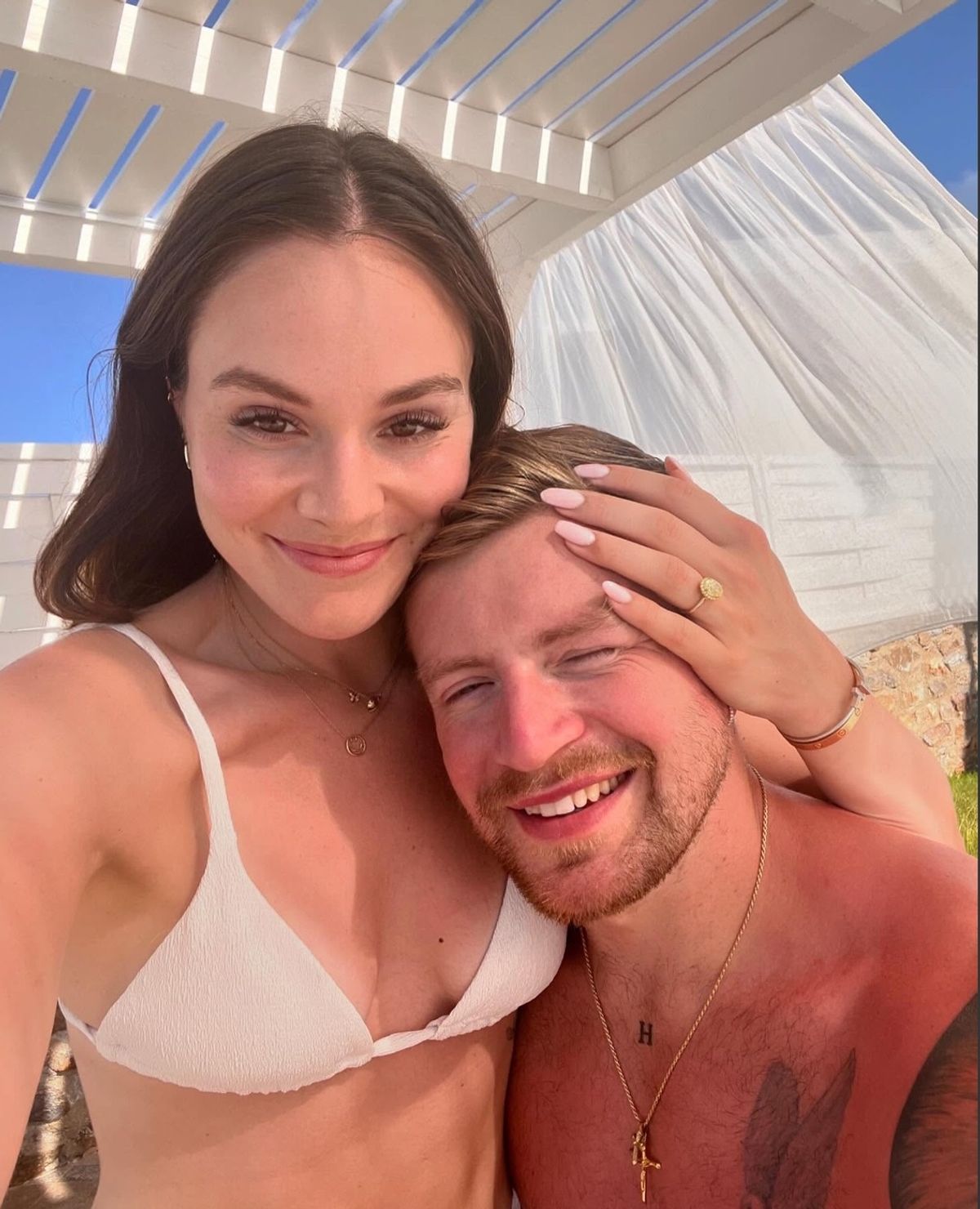 Holly wears a bikini and clutches Adam to her chest in a sunny holiday snap 