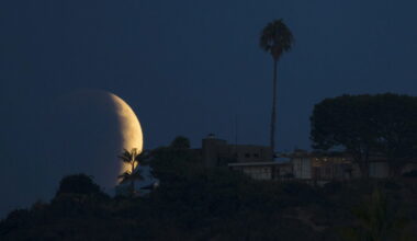 A blood red moon rises behind a hilltop residence in Solana Beach