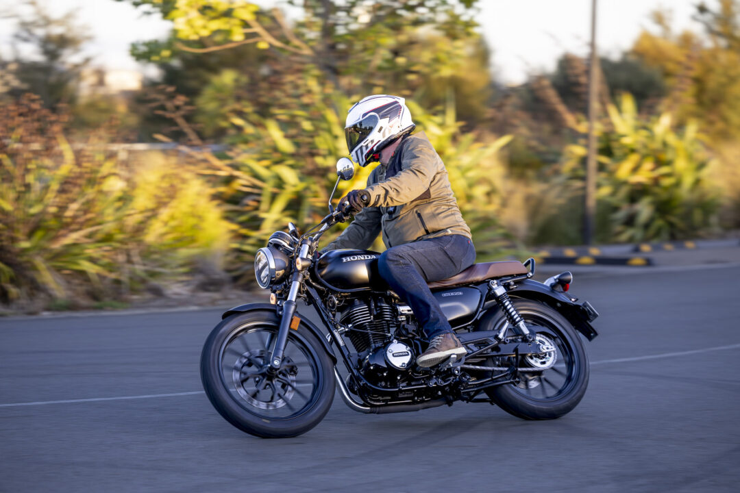 Honda GB350 action riding around a corner in the sun