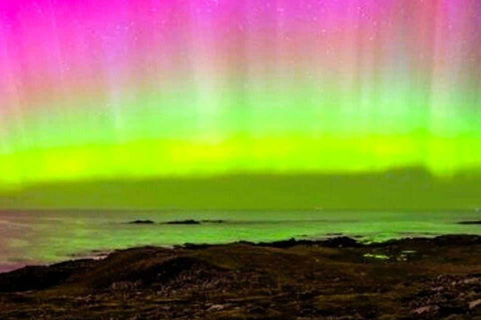 The Northern Lights are glowing layers of pink, green, and purple colours.