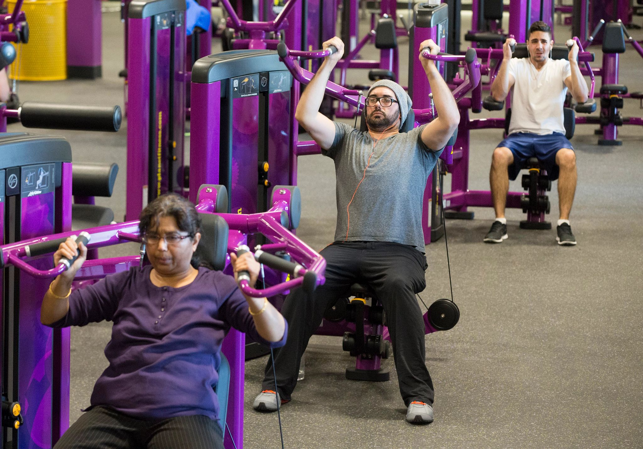 TORONTO, ON -  JANUARY 7: Paul Docarmo, of Toronto (centre), works out at Planet Fitness, a low cost gym chain that opened its first Canadian branch in Toronto. The franchise is growing quickly thanks to low prices and its "judgement free-zone" mantra.        (Bernard Weil/Toronto Star via Getty Images) (Toronto Star via Getty Images)