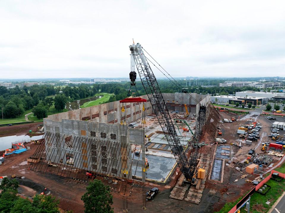 Images shows a crane working on a large-scale construction site.