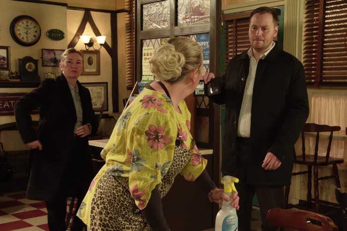 Two police officers approach Bernie in the cafe late at night in a scene from Coronation Street