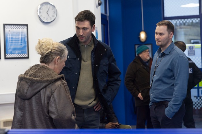 Kit and another police officer talk to Bernie in the station in Coronation Street