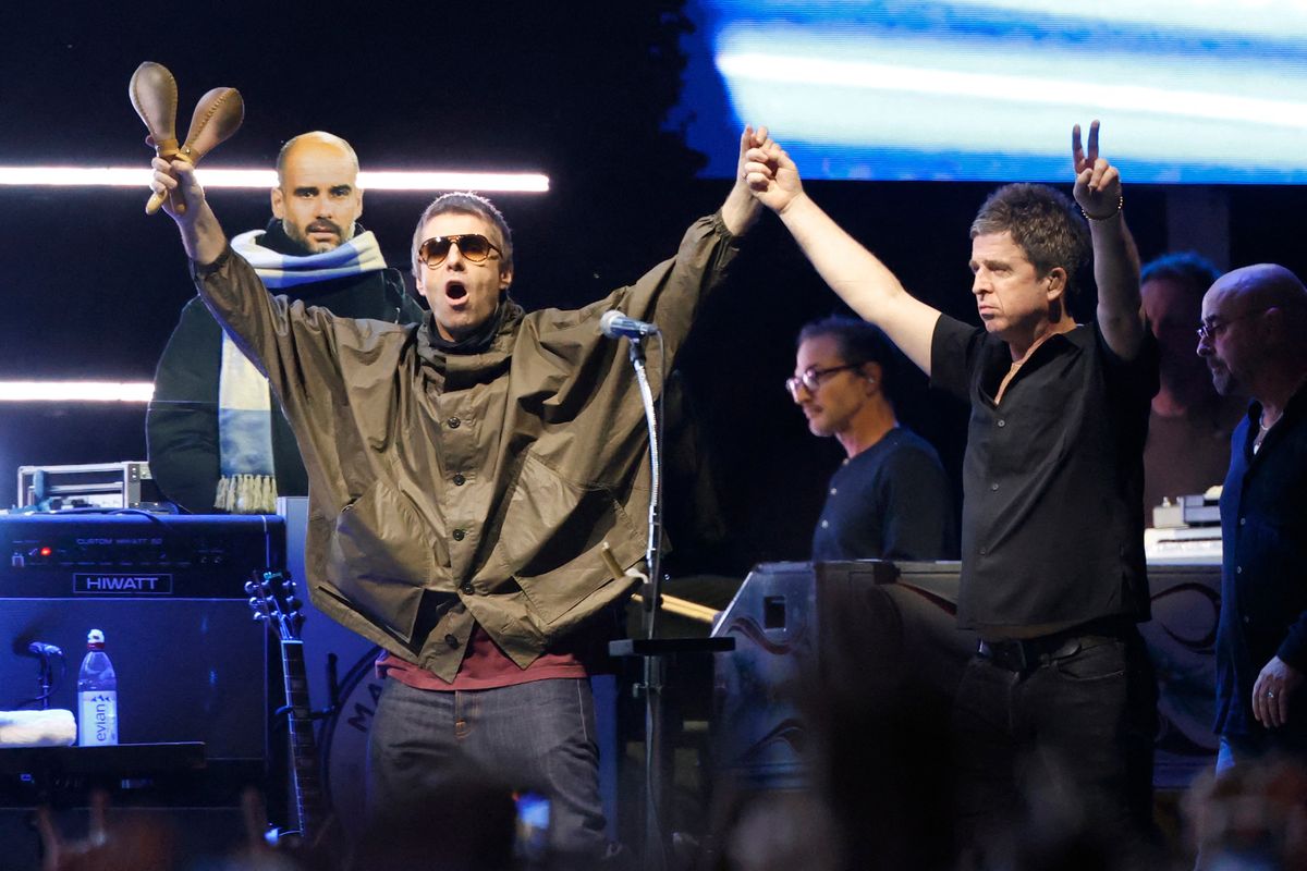Members of British rock band Oasis, including Liam Gallagher and Noel Gallagher, arrive on stage at Soldier Field in Chicago on August 28, 2025, during their reunion tour. 