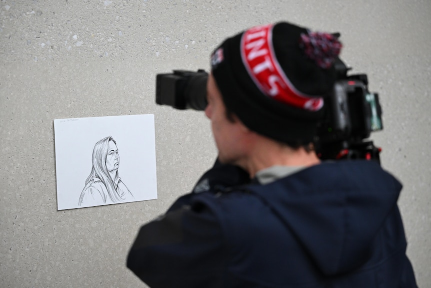 A cameraman takes a photo of a paper sketch.  