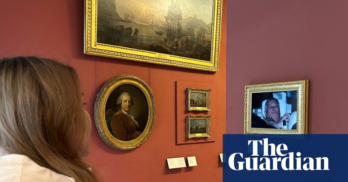 Activists hang photo of Andrew leaving police custody in the Louvre | UK news
