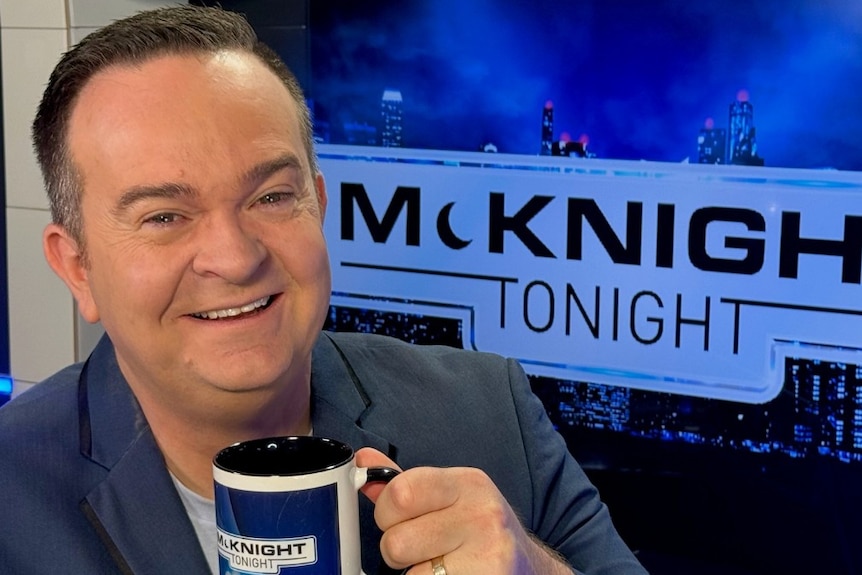 A man with short dark hair, smiling at the camera.