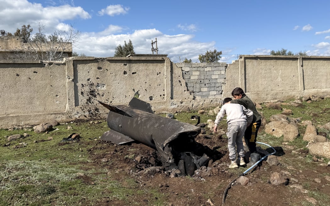 Syrian children inspect the wreckage of an Iranian rocket that was reportedly intercepted by Israeli forces in the southern countryside of Quneitra, near the Golan Heights, close to the town of Ghadir al-Bustan. The United States and Israel launched strikes against Iran on February 28, with Israel's public broadcaster reporting that supreme leader Ayatollah Ali Khamenei had been targeted, as the Islamic republic retaliated with barrages of missiles at Gulf states and Israel. (Photo by Bakr ALKASEM / AFP)